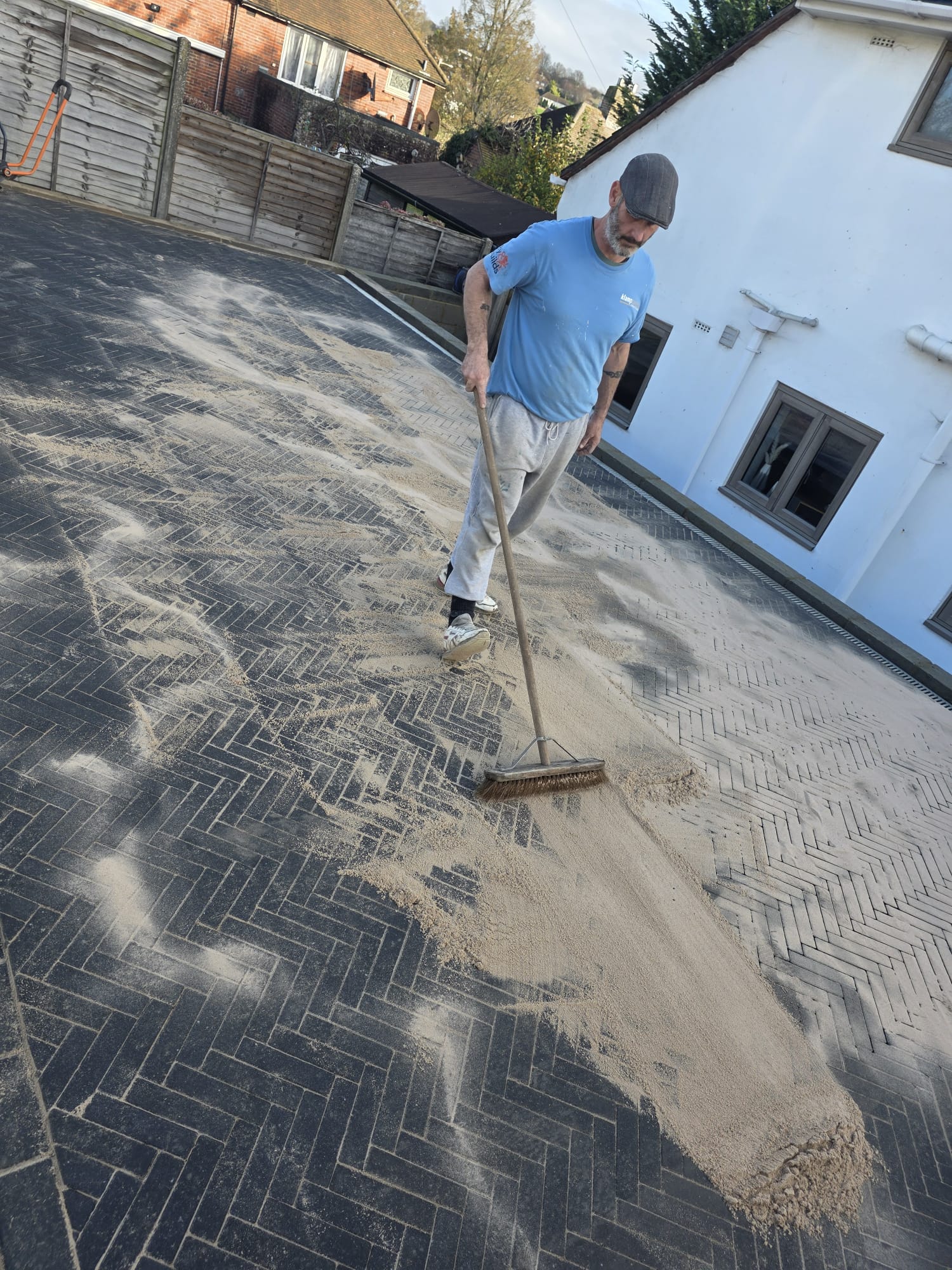 Brushing kiln sand into block paving